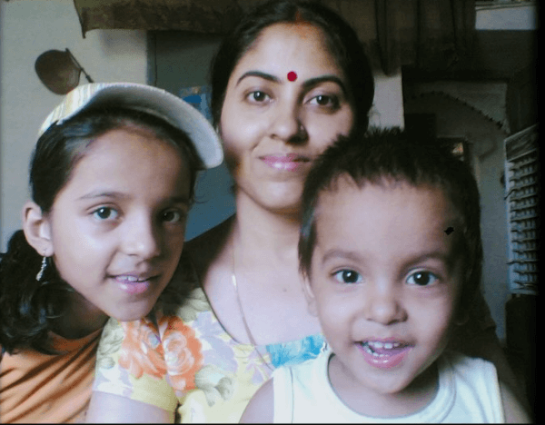 Childhood photo of Shivangi in a cap, her mother in a floral top, and her younger brother smiling together